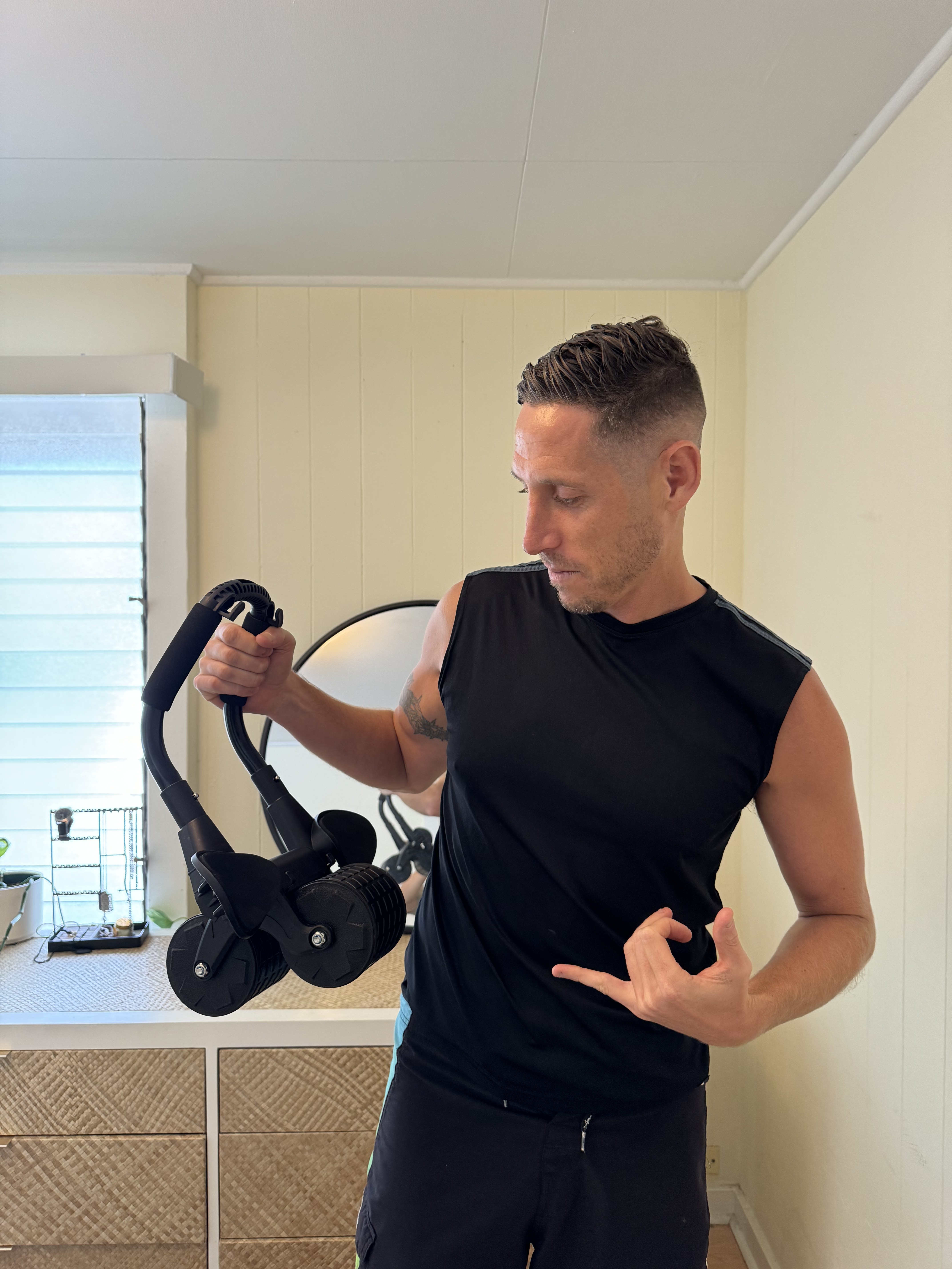 Man holding the PostureFlex Ab Roller and pointing to his core
