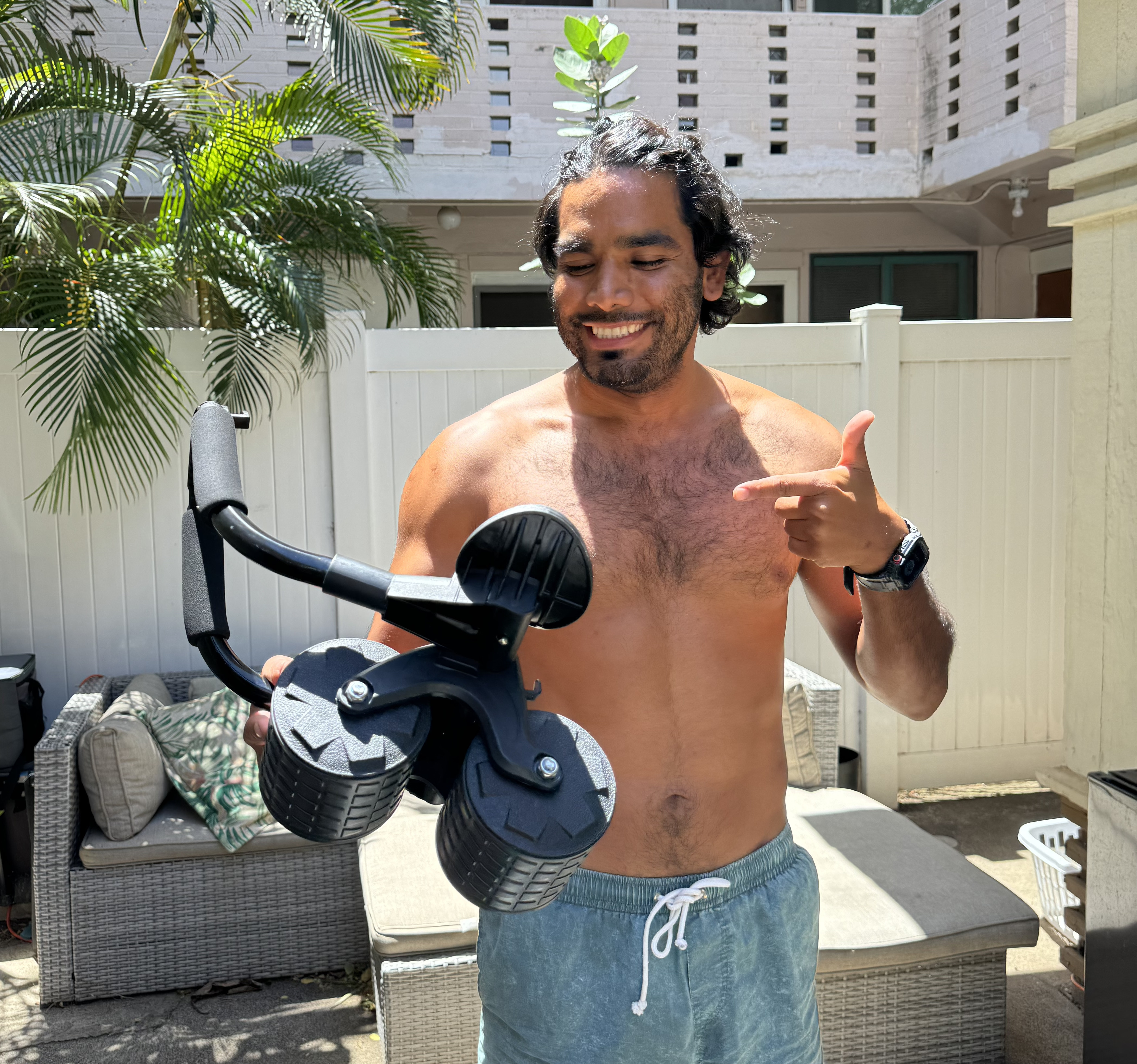 Man holding the PostureFlex Ab Roller outdoors on a sunny patio